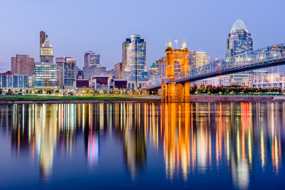 Cincinnati Ohio - Elegant Outdoor Lighting Design Cincinnati skyline at dusk with the Roebling Suspension Bridge over the river and reflections in calm water.
